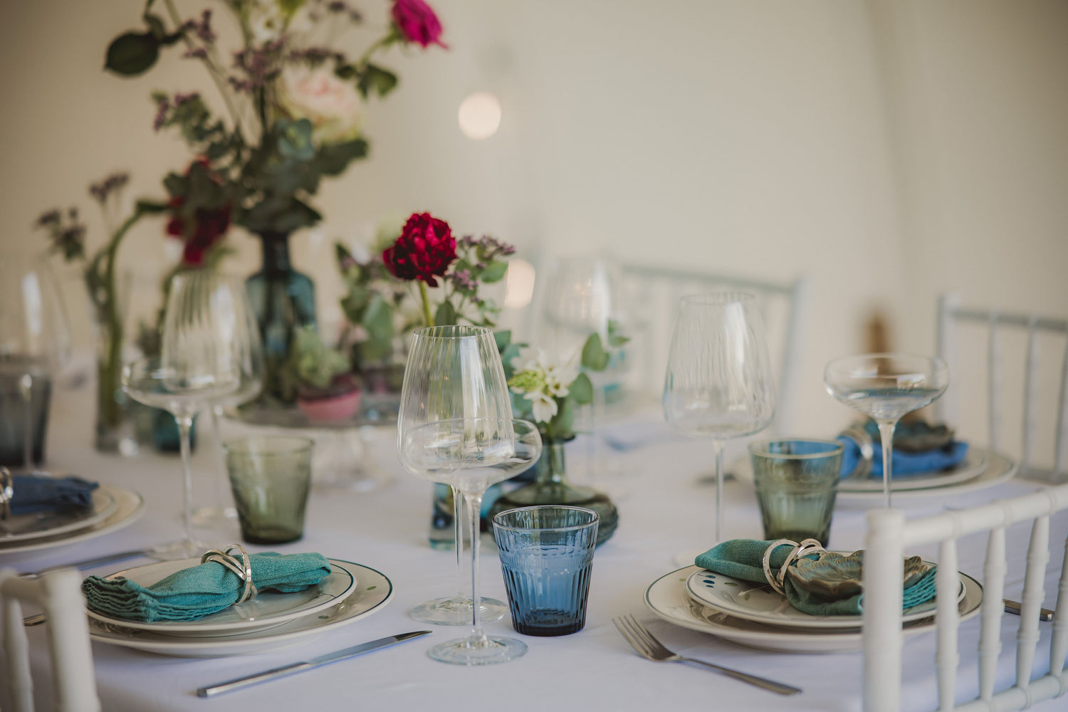 Close up of a wedding reception table with red peonies and roses