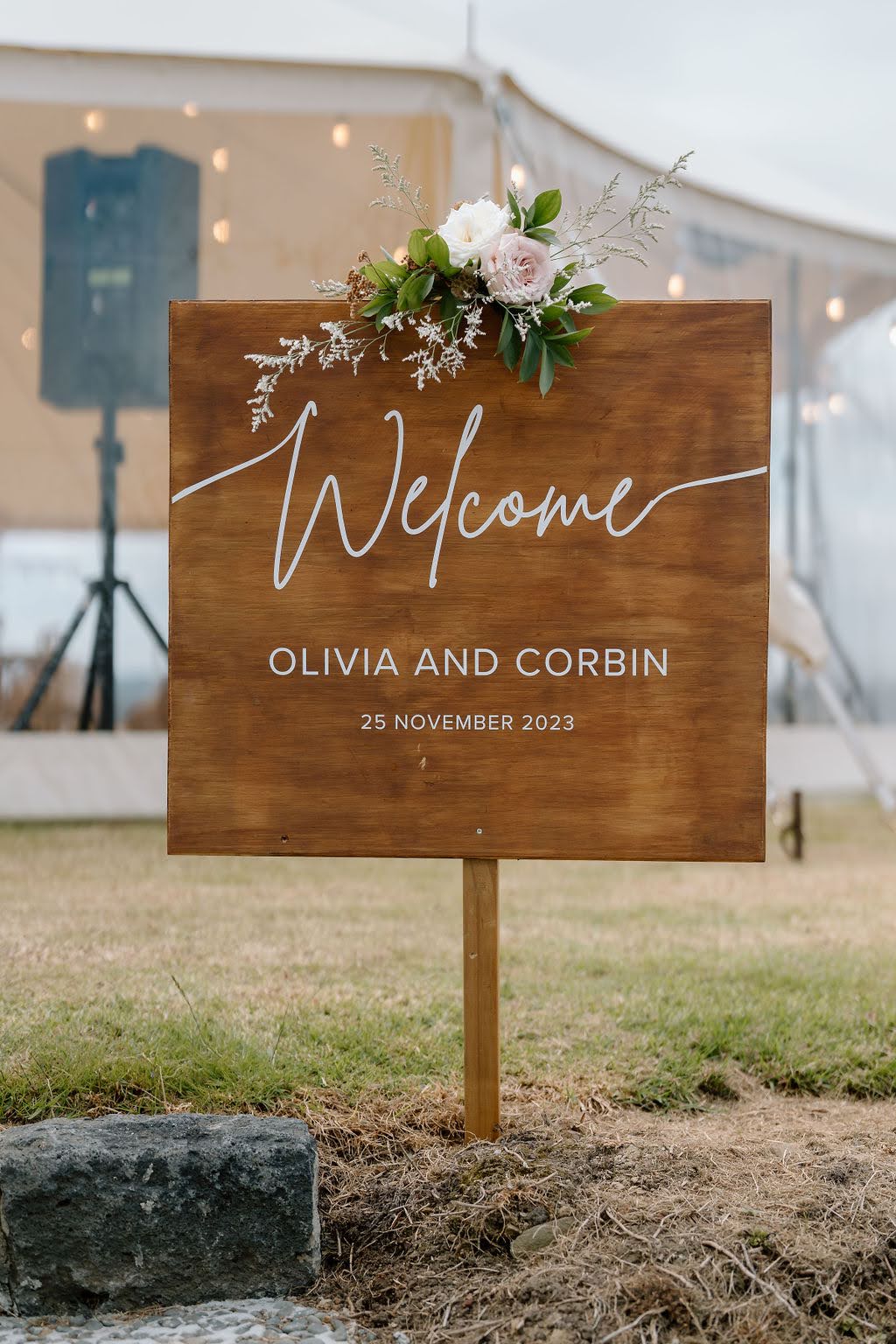 Flowers on top of a wedding welcome sign