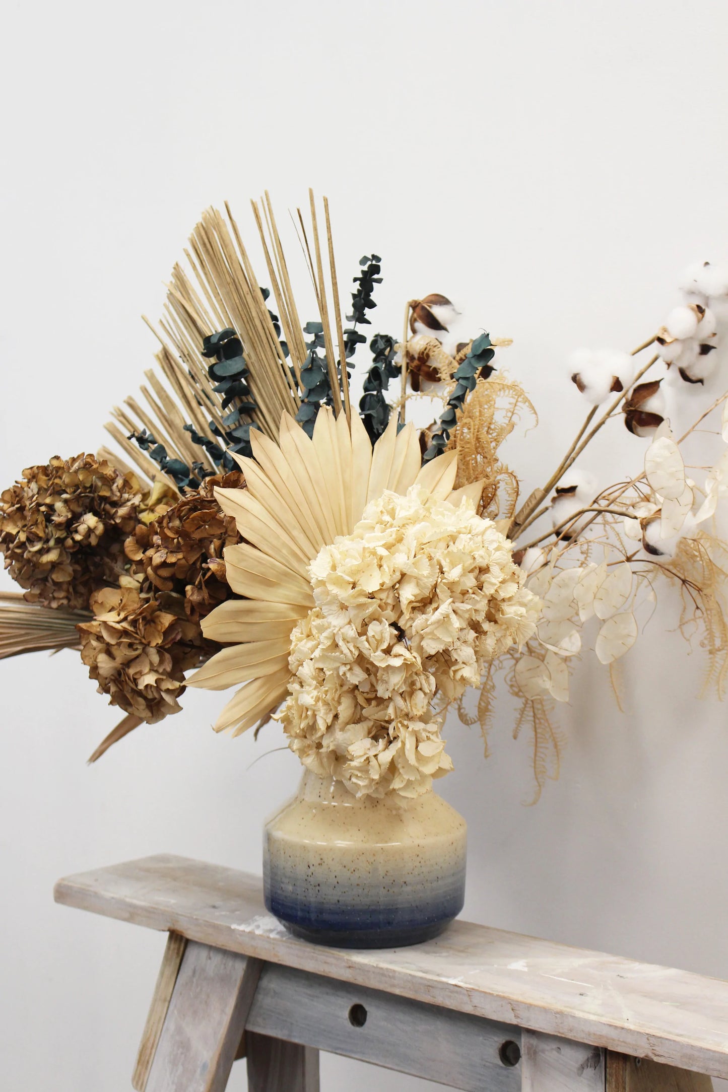 Dried flower arrangement in a ceramic vase