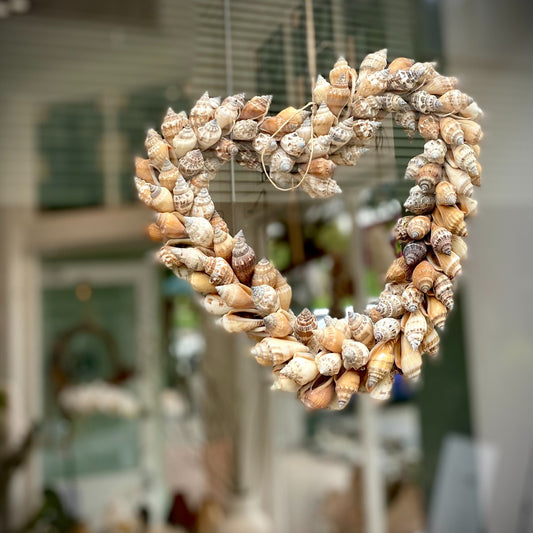 Hearth shaped brown shell wreath hanging in a window