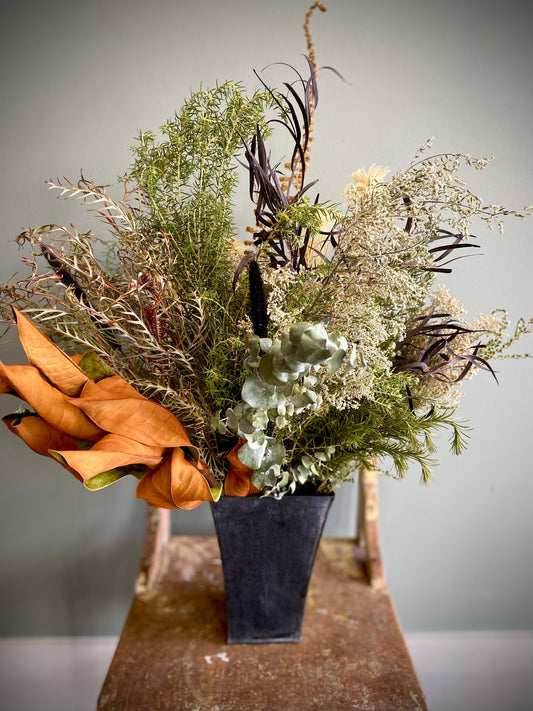 Dried flower foliage in a rustic black tin vase