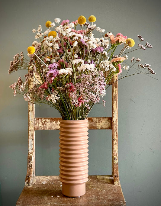 Dried wild flowers in a nude ceramic vase