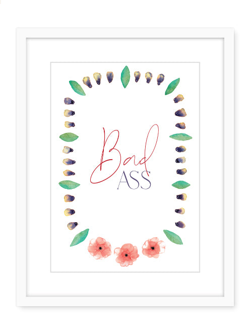 Framed art showing a flower necklace with text in the middle that reads Bad Ass
