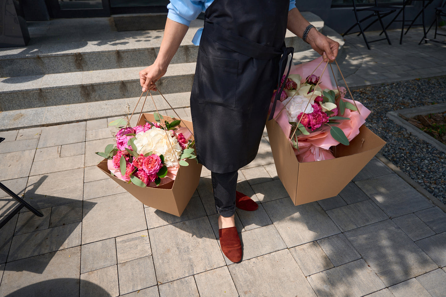 Florist walking with two gift bags full of fresh flowers